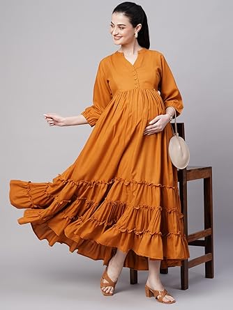 pregnant women wearing flowy orange maternity maxi dress with tiered ruffle design, posing gracefully with hand on baby bump.