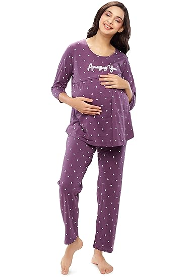 Pregnant woman wearing purple polka dot maternity nightwear set with long sleeves and relaxed fit, smiling while holding baby bump.